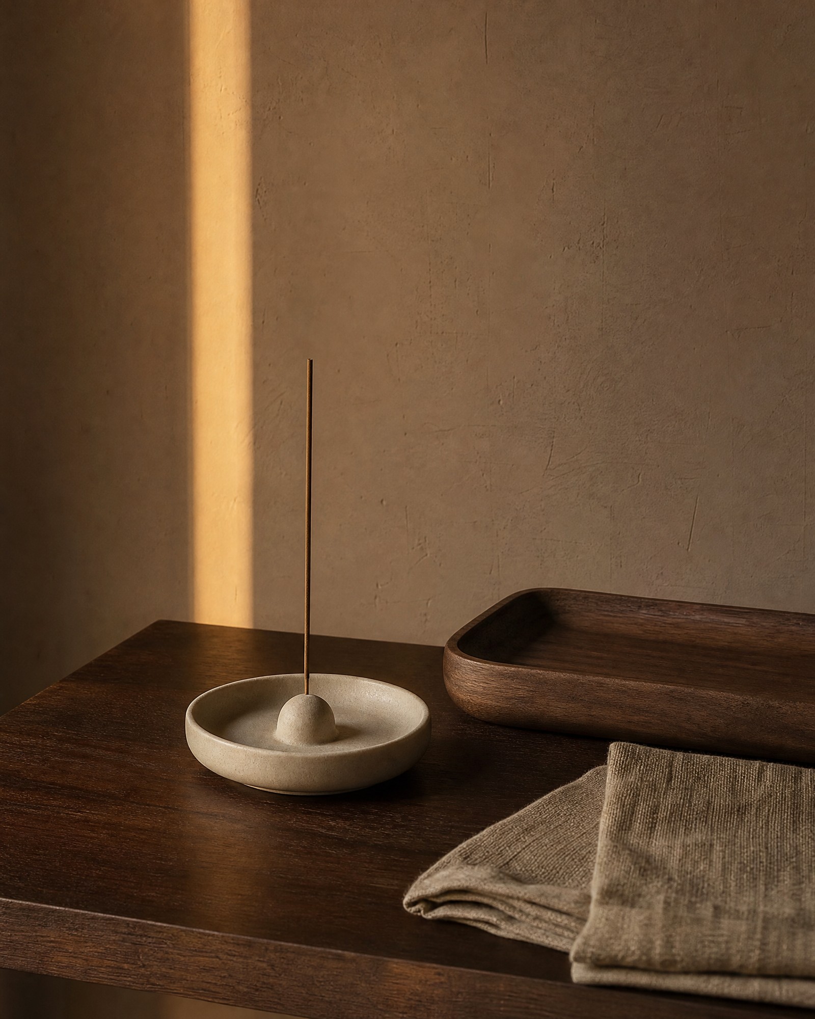 Ceramic incense holder and non-ingestible ritual accessories on a dark wood tray